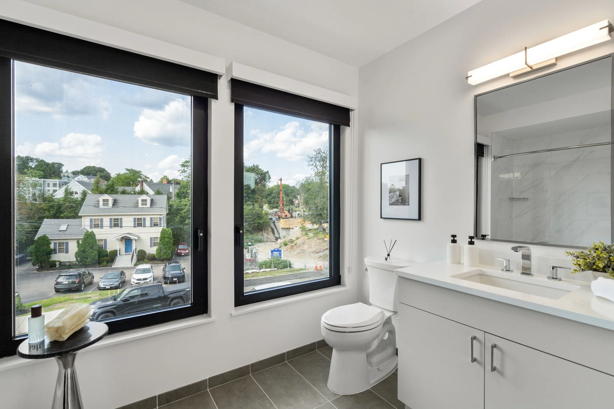 Bathroom with a large window, vanity, and toilet