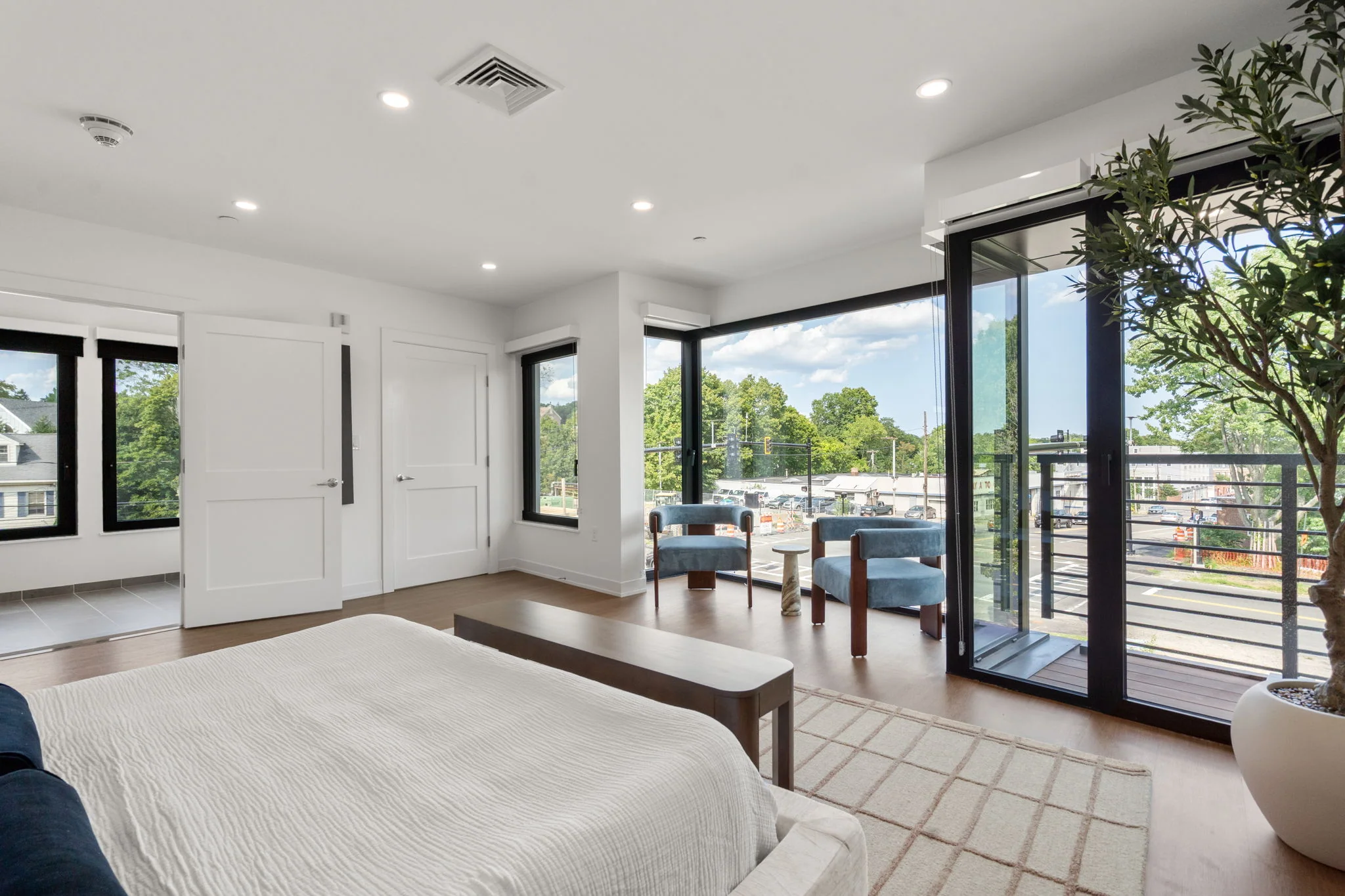 Bedroom looking toward blue armchairs and balcony doors