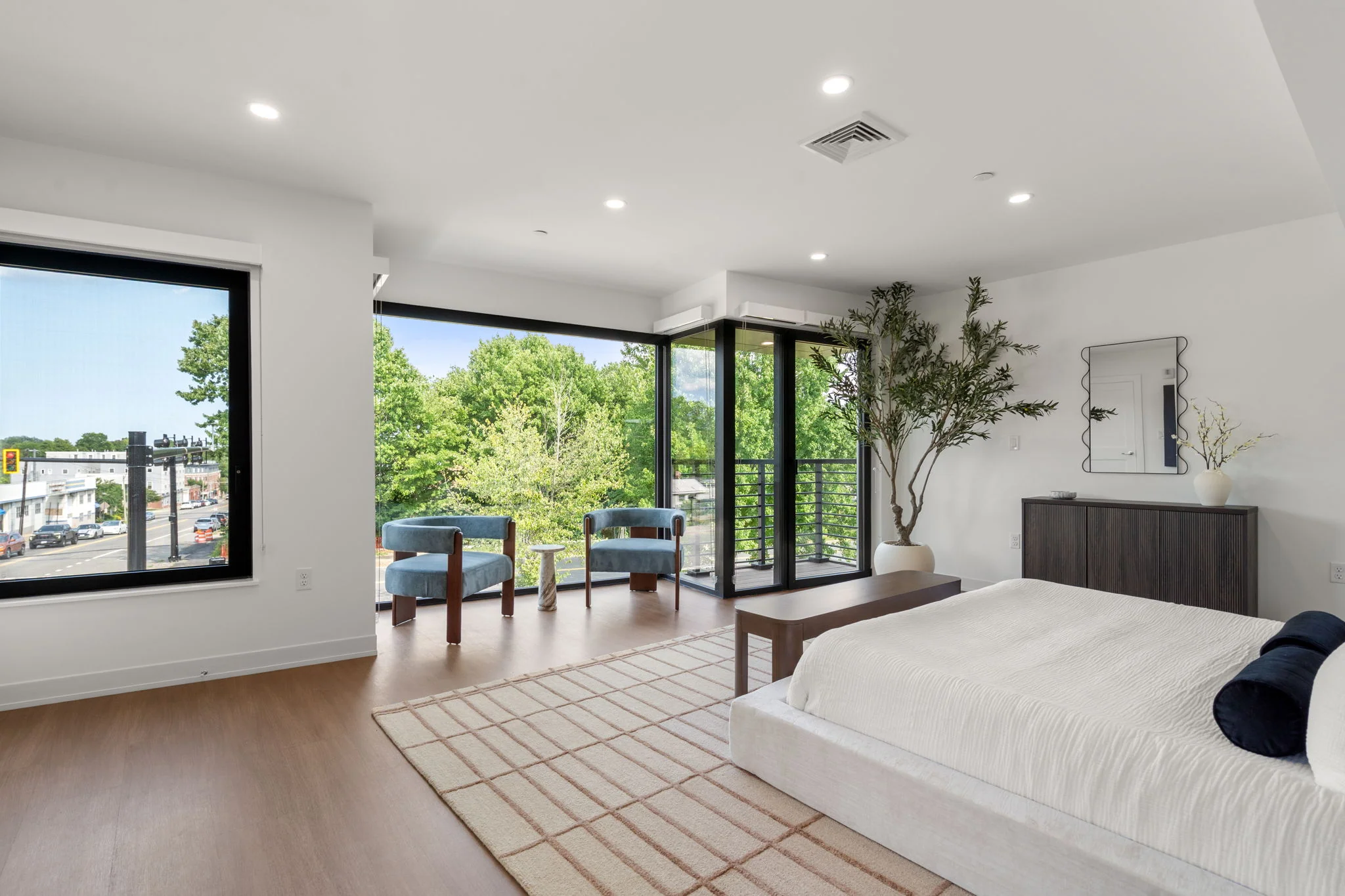Bedroom with corner windows and a sitting area beside the bed