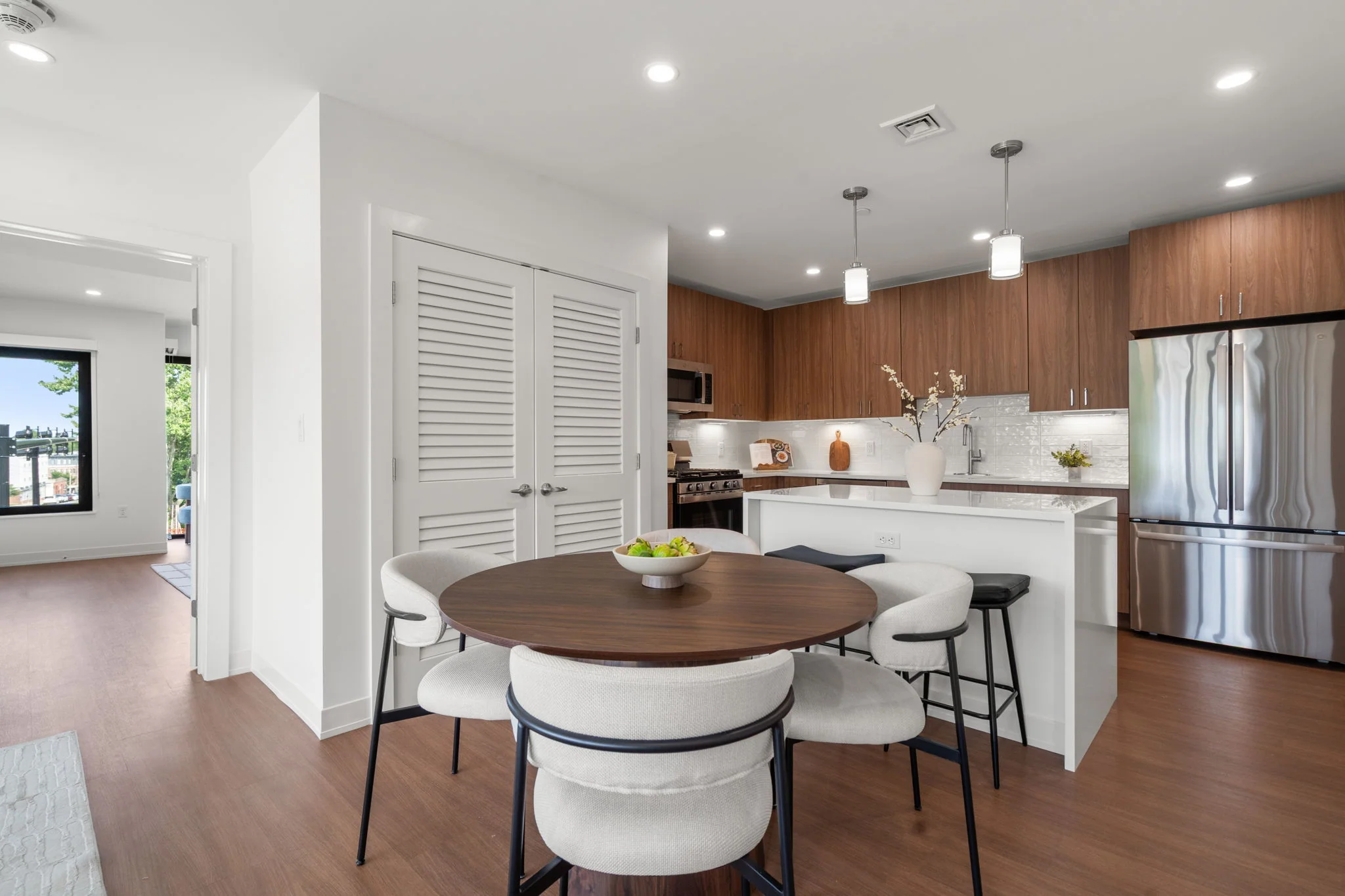 Dining table beside the kitchen island and stainless steel refrigerator