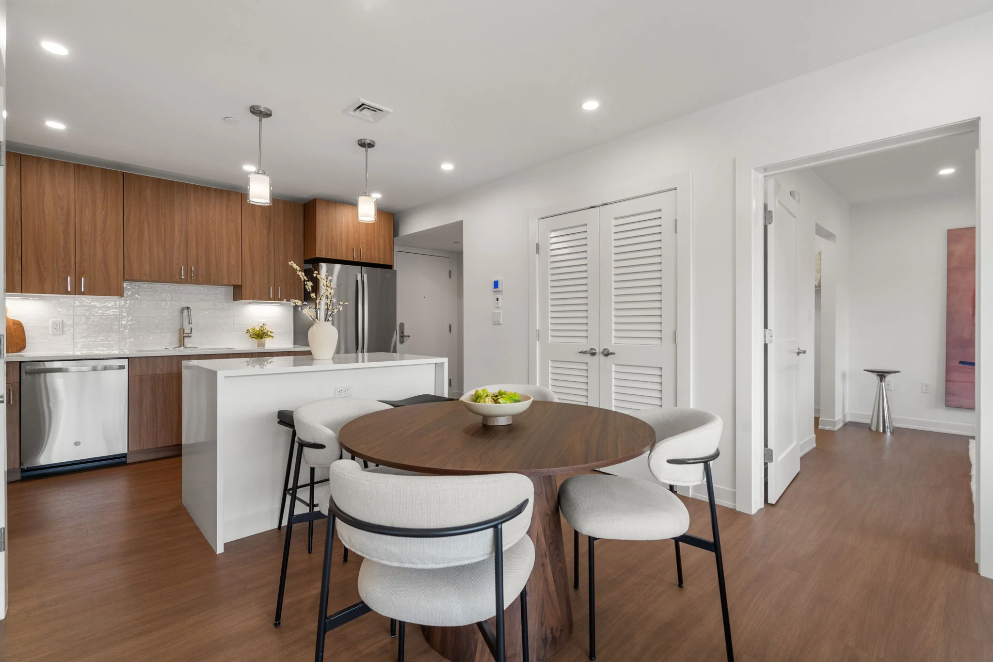 Kitchen and dining area with wood cabinetry and pendant lighting