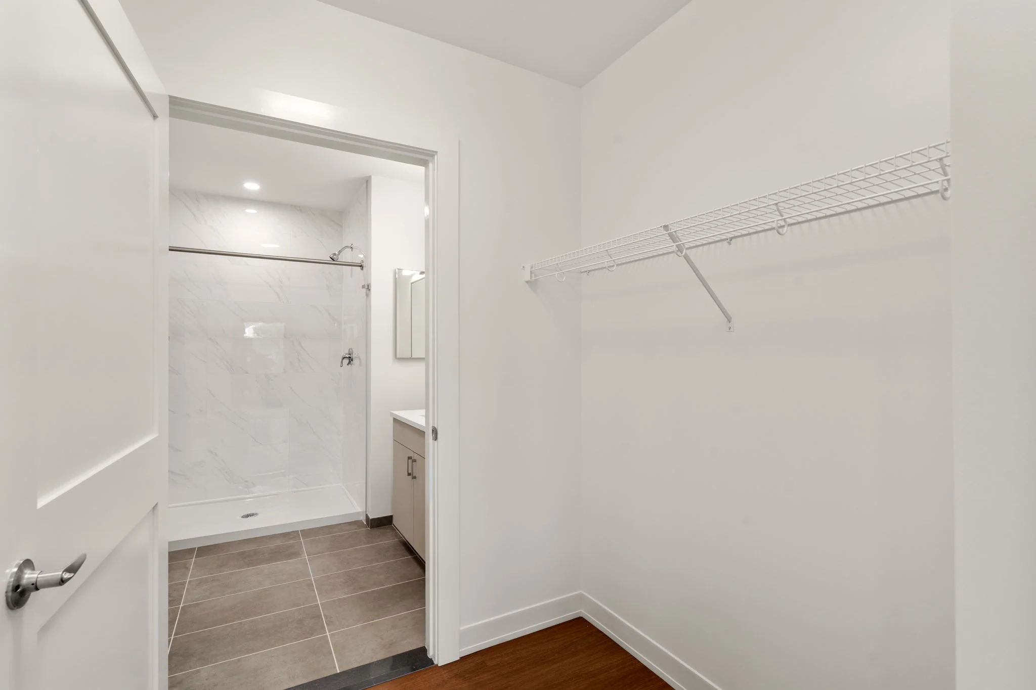 Walk-in closet with shelving and a doorway to the bathroom